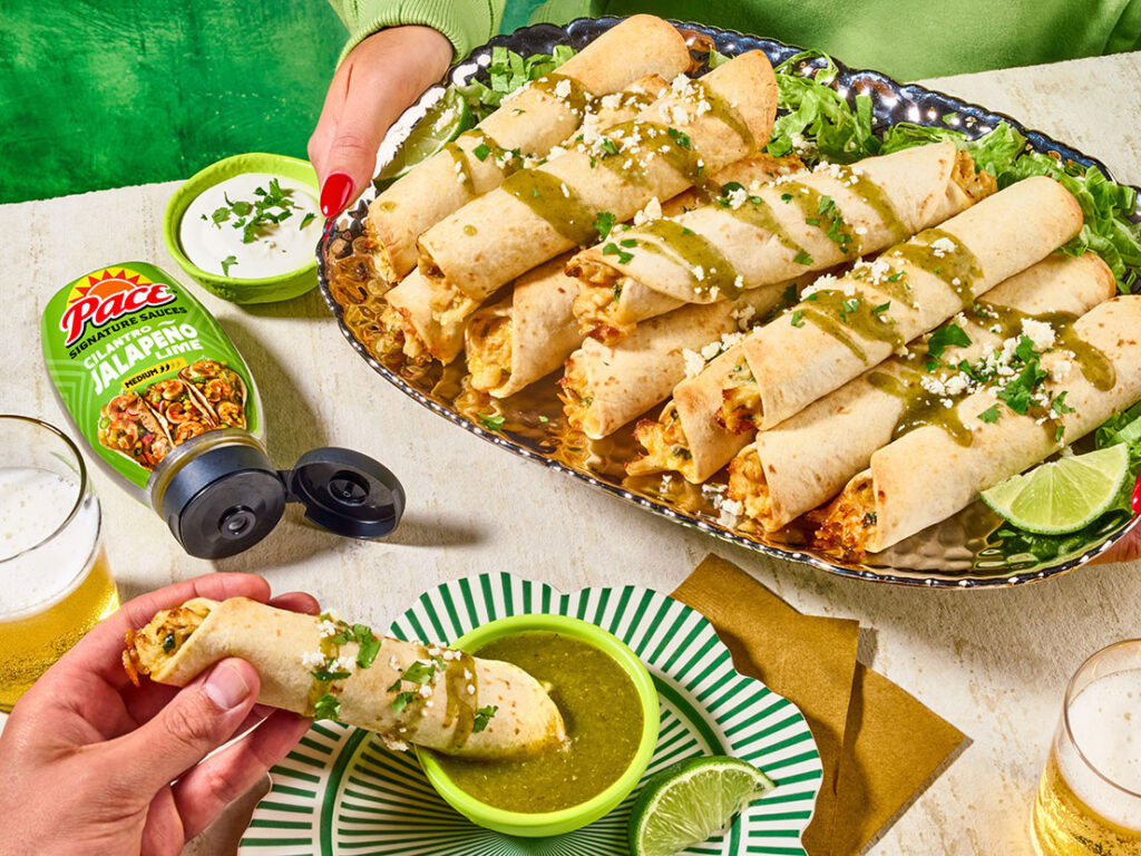 An image of prepared Creamy Verde Chicken Taquitos made with chicken, Cheddar cheese, cream cheese, Pace® Signature Sauces Cilantro Jalapeño Lime Sauce, cilantro and flour or corn tortillas.