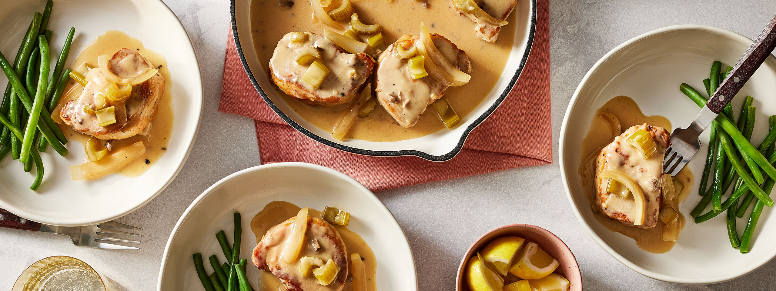 An image of prepared 30-Minute Pork Chops with White Wine Mushroom Sauce made with pork chops, celery, onion, white wine, Swanson® Unsalted Chicken Stock and Campbell's® Condensed Cream of Mushroom Soup.